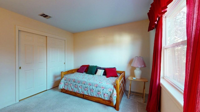 carpeted bedroom featuring visible vents and a closet