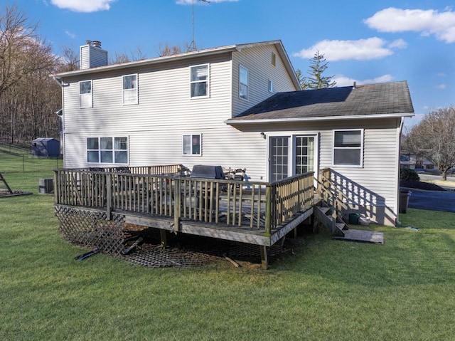 back of property featuring a wooden deck, central air condition unit, a lawn, and a chimney