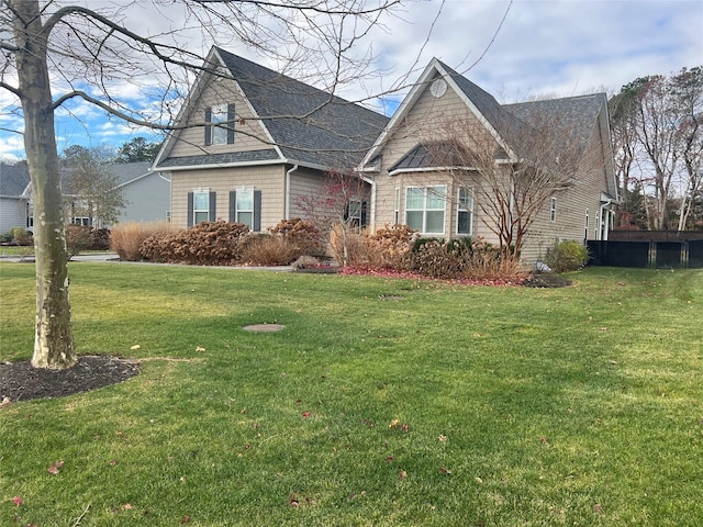 view of front facade featuring a front lawn and a shingled roof