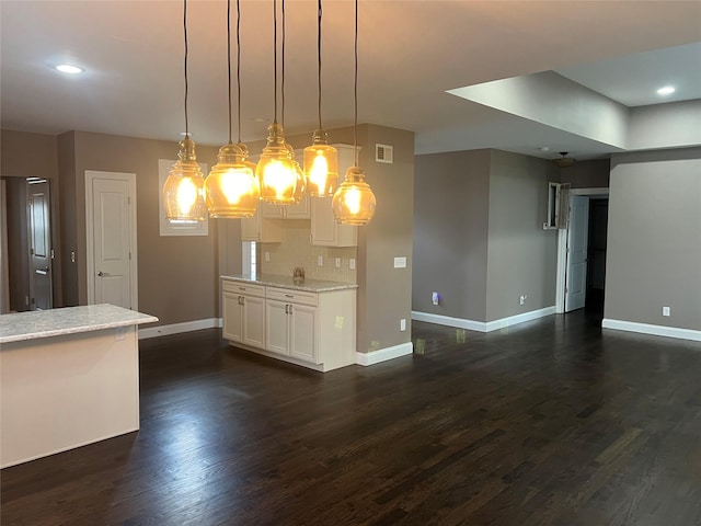 kitchen featuring decorative backsplash, hanging light fixtures, baseboards, and dark wood-style flooring