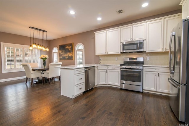 kitchen with a peninsula, plenty of natural light, visible vents, and appliances with stainless steel finishes