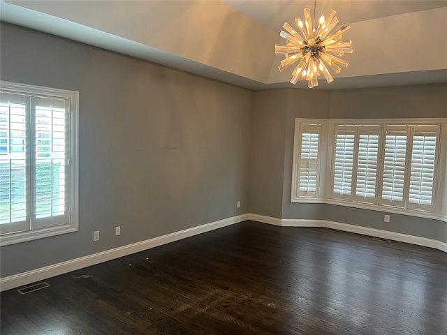 empty room with a notable chandelier, baseboards, visible vents, and dark wood-style flooring