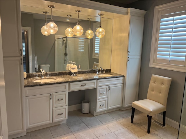 full bath featuring double vanity, a stall shower, toilet, and a sink