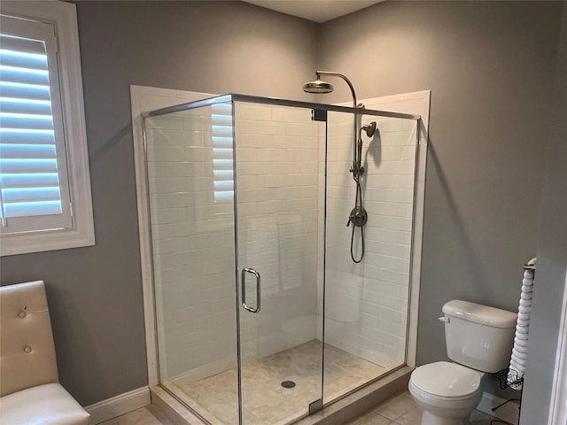 full bathroom with tile patterned floors, baseboards, toilet, and a shower stall