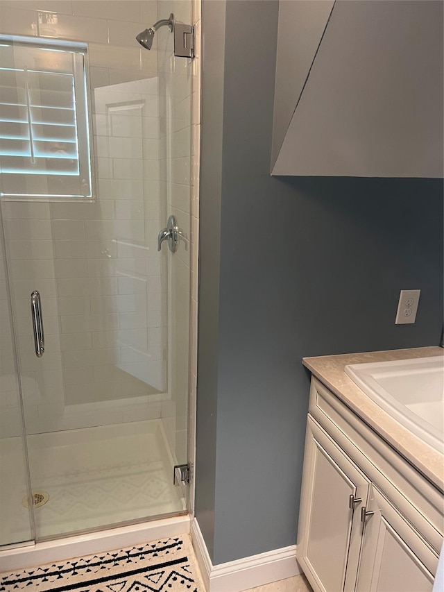 full bath with baseboards, a stall shower, and vanity