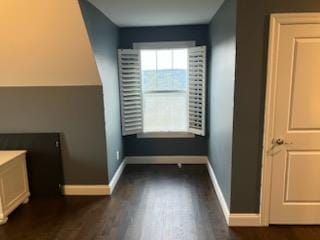 interior space with baseboards and dark wood-style flooring