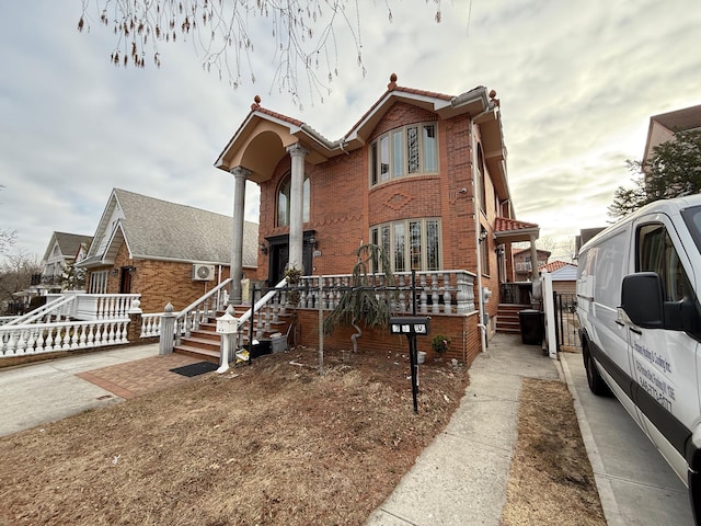 view of front of property featuring a tiled roof and brick siding