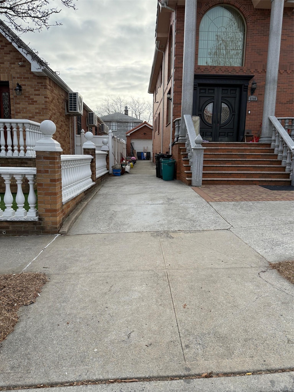 entrance to property featuring a garage and brick siding