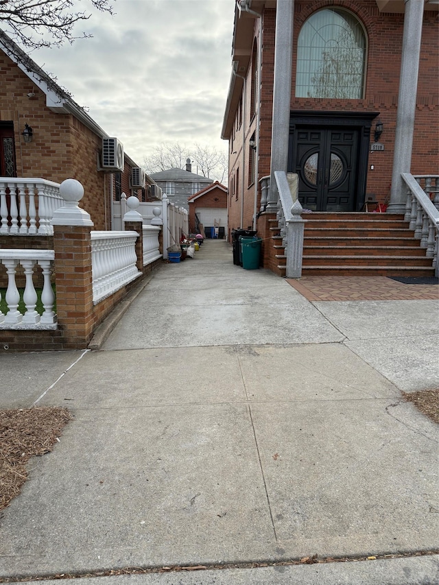 entrance to property featuring a garage and brick siding