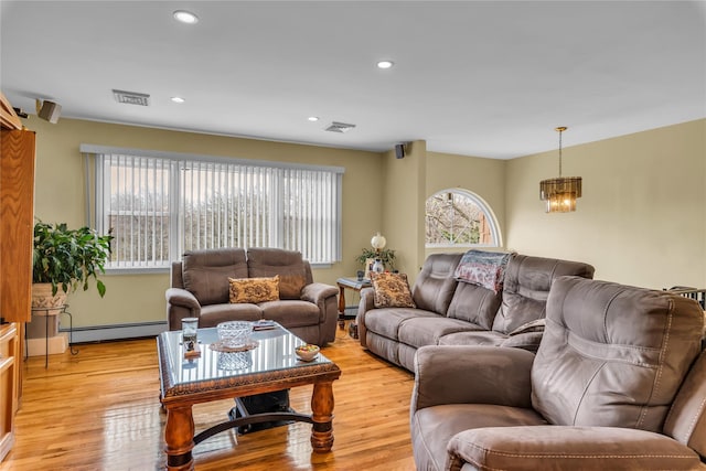 living room featuring visible vents, light wood finished floors, a baseboard heating unit, and recessed lighting