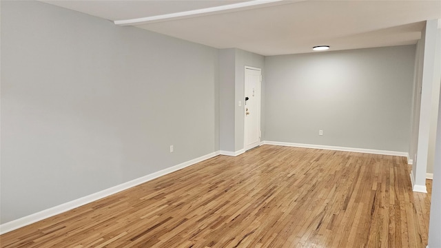 empty room with baseboards and light wood-style floors