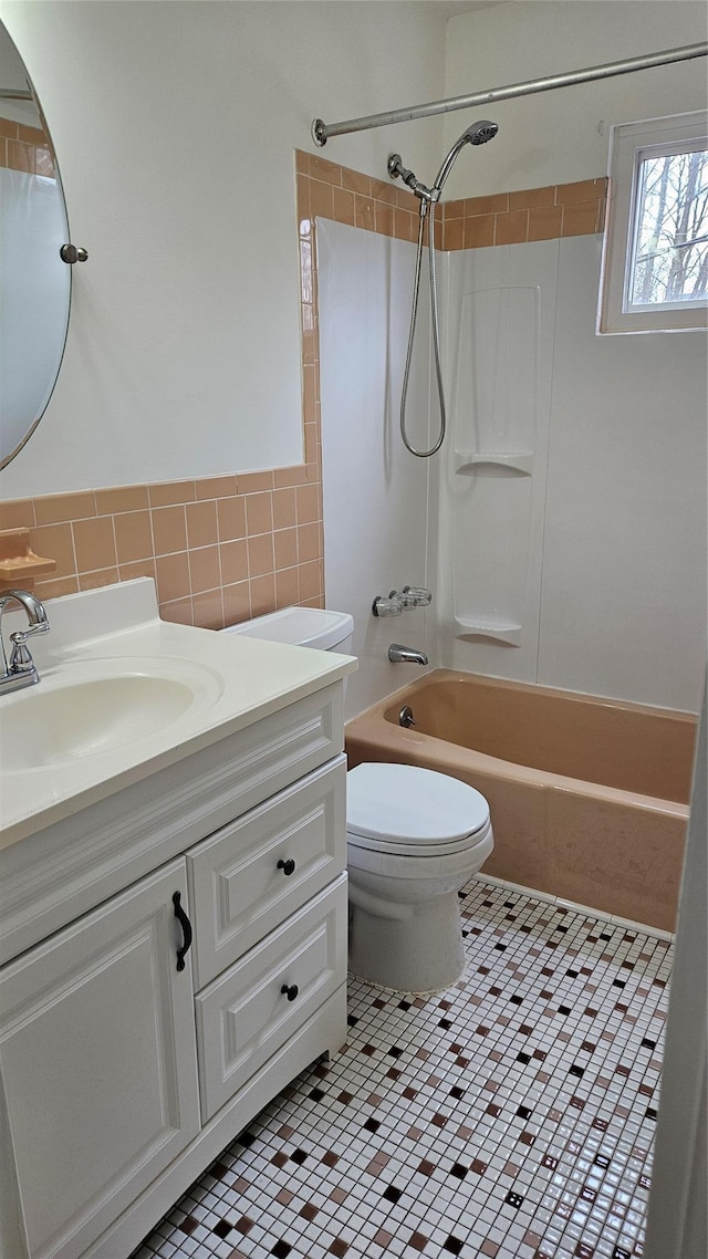 full bathroom featuring tile patterned floors, toilet, tile walls, shower / bath combination, and vanity