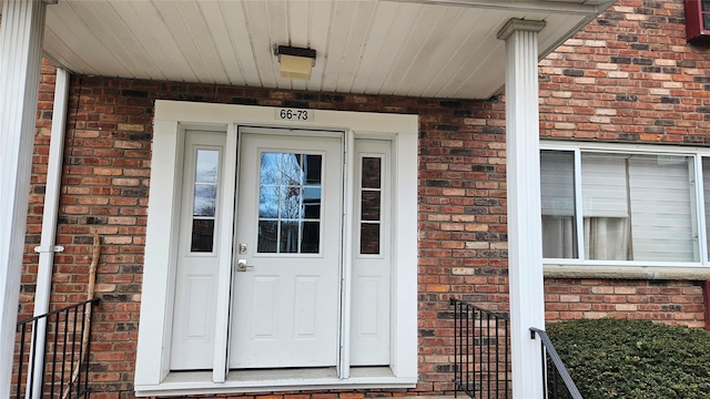 doorway to property featuring brick siding