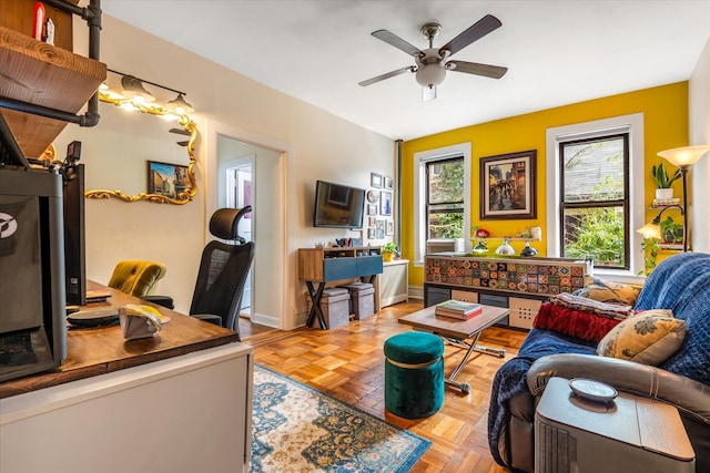 living room with baseboards and a ceiling fan