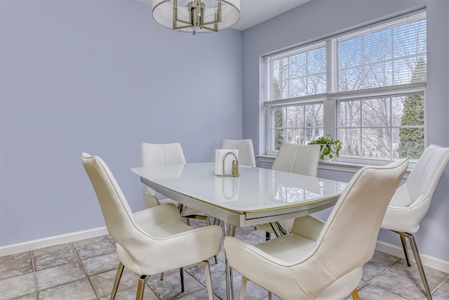 dining area with a notable chandelier and baseboards