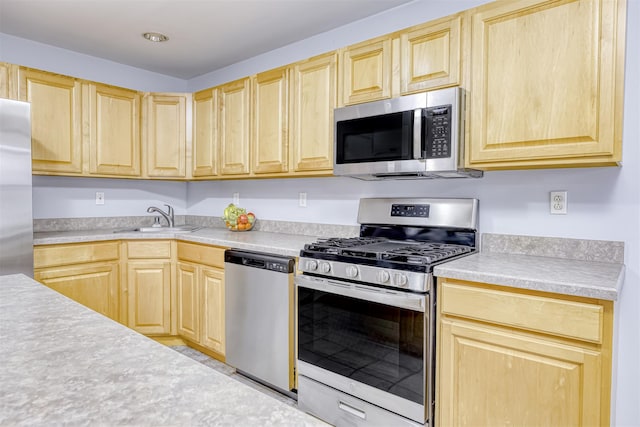 kitchen featuring light countertops, light brown cabinets, appliances with stainless steel finishes, and a sink