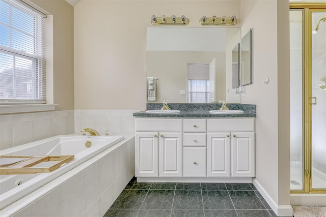 full bathroom featuring a garden tub, double vanity, a stall shower, and a sink