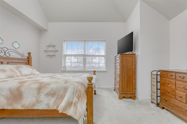 bedroom with baseboards, lofted ceiling, and light colored carpet