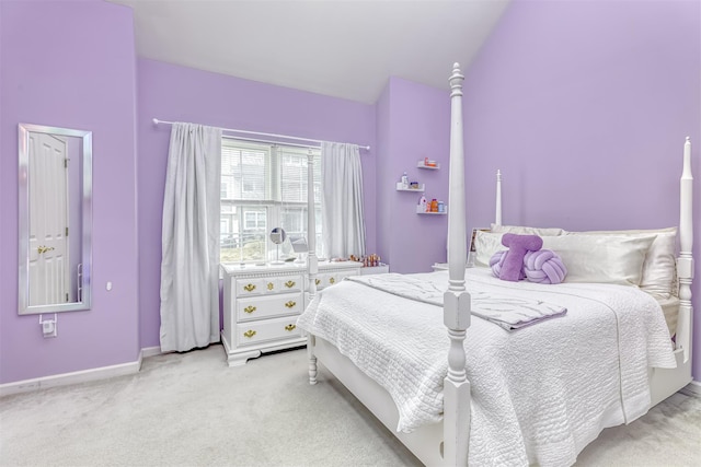 carpeted bedroom featuring lofted ceiling and baseboards