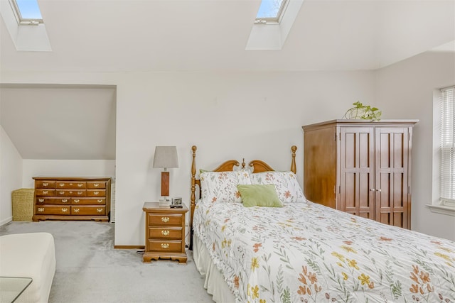 bedroom featuring vaulted ceiling with skylight, baseboards, and carpet floors