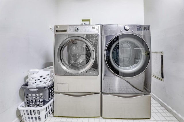 laundry room with washing machine and clothes dryer, laundry area, and baseboards