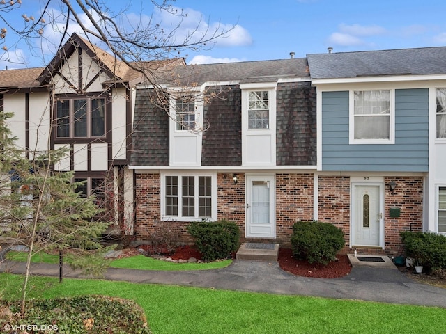 view of front of property featuring brick siding and a shingled roof