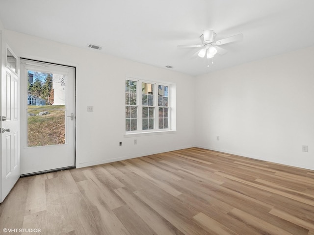 empty room with visible vents, baseboards, light wood-type flooring, and ceiling fan