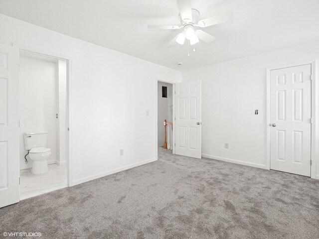 unfurnished bedroom featuring ensuite bath, baseboards, carpet floors, and ceiling fan