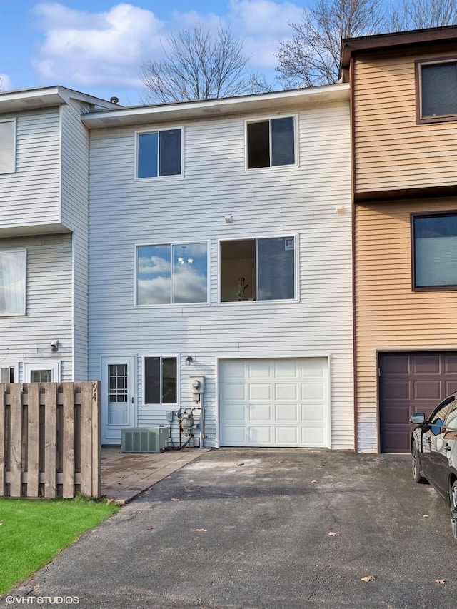 view of front of home featuring an attached garage, driveway, and fence