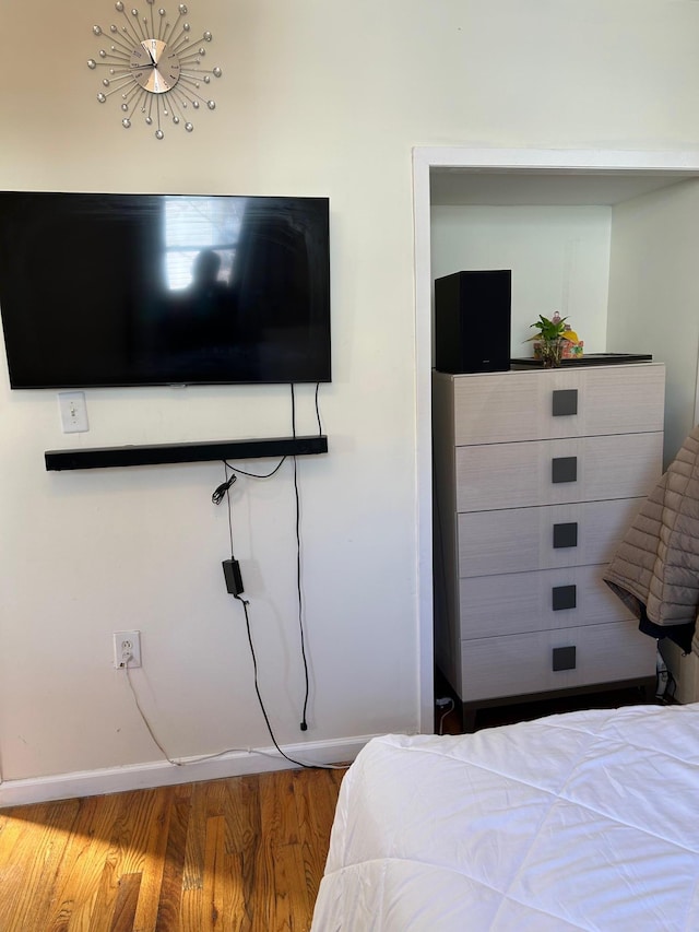 bedroom featuring baseboards and wood finished floors