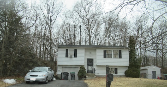 split foyer home with aphalt driveway and a chimney