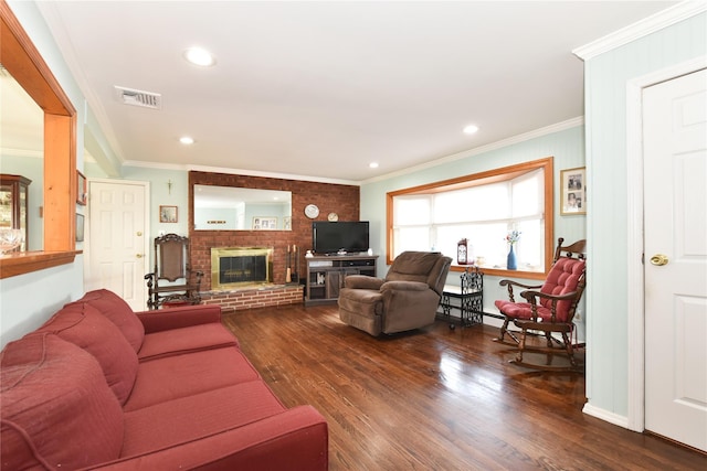 living room featuring visible vents, wood finished floors, a fireplace, and ornamental molding