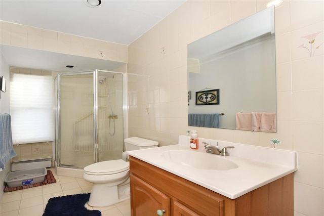 bathroom featuring a stall shower, tile patterned flooring, tile walls, toilet, and baseboard heating