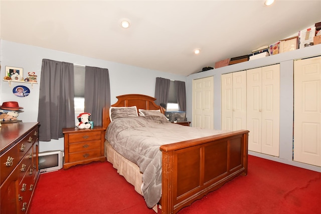 bedroom featuring recessed lighting, two closets, dark carpet, and vaulted ceiling