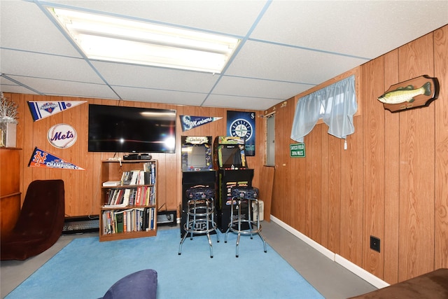 interior space with wooden walls and a drop ceiling