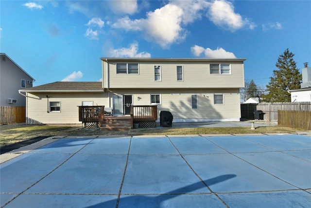 back of property featuring a wooden deck, a patio, and fence