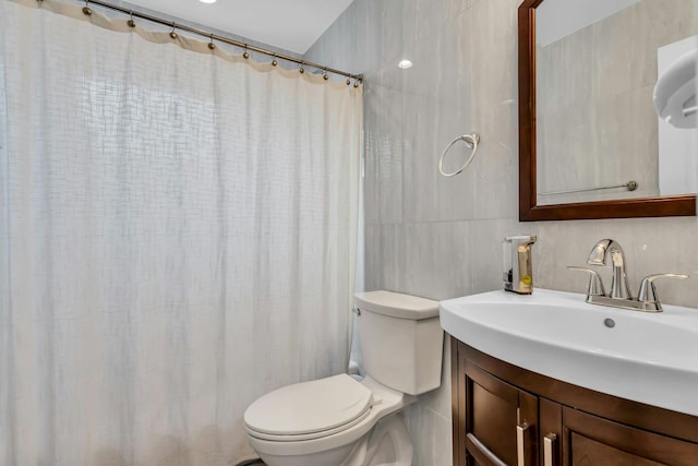 full bathroom with vanity, tile walls, curtained shower, and toilet