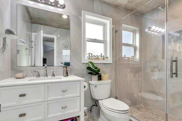 full bath with toilet, tile walls, a shower stall, decorative backsplash, and vanity