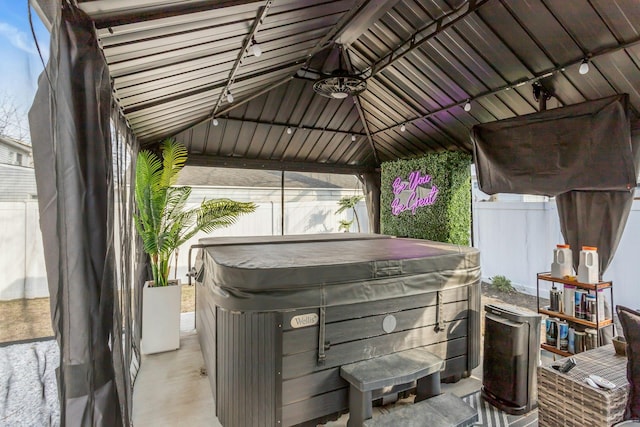 view of patio / terrace featuring fence and a hot tub