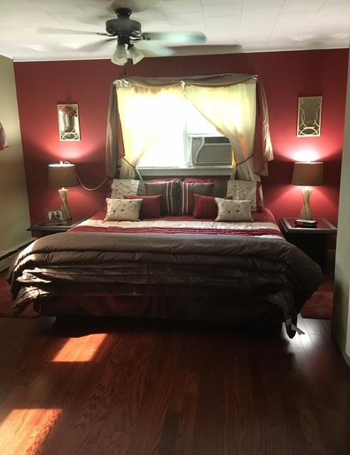 bedroom featuring a ceiling fan, cooling unit, and wood finished floors