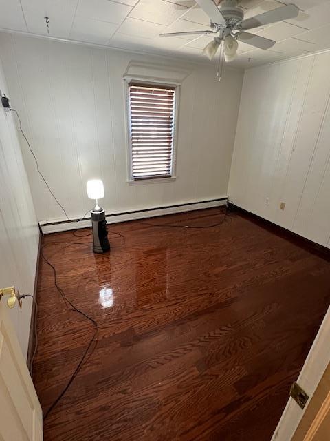 unfurnished room with dark wood-type flooring, baseboards, and ceiling fan