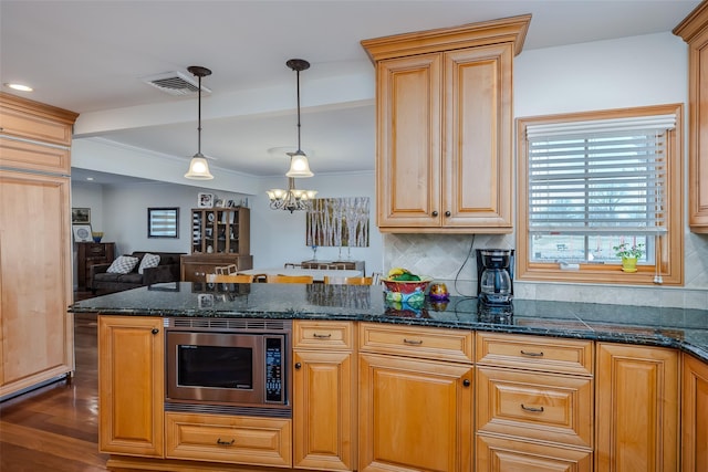 kitchen with dark wood-style floors, visible vents, stainless steel microwave, open floor plan, and backsplash