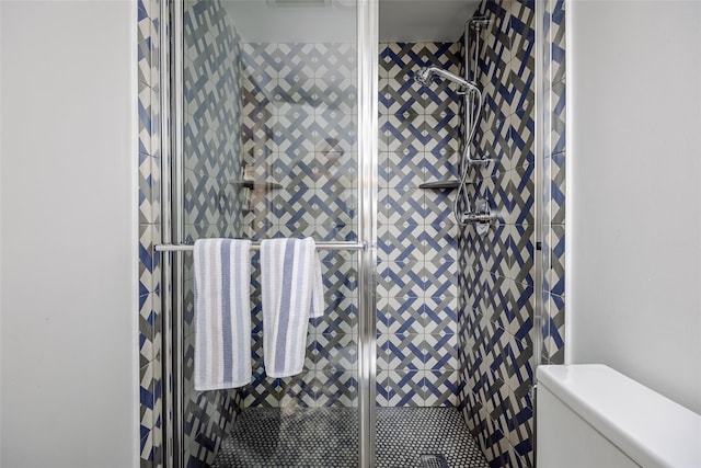 bathroom featuring a shower stall and toilet