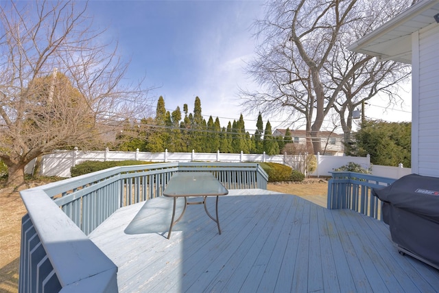 deck with a grill and a fenced backyard