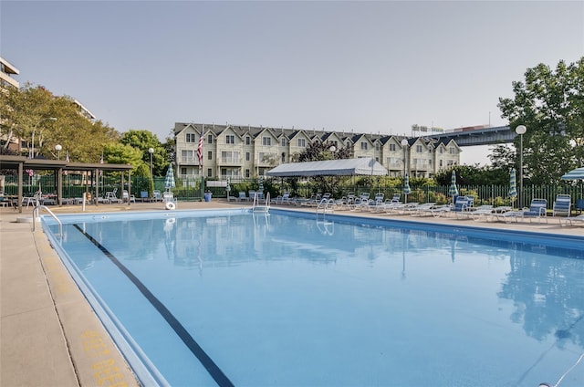 view of swimming pool featuring a patio and fence