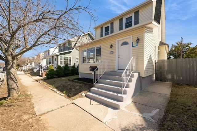 view of front of house with a residential view and fence