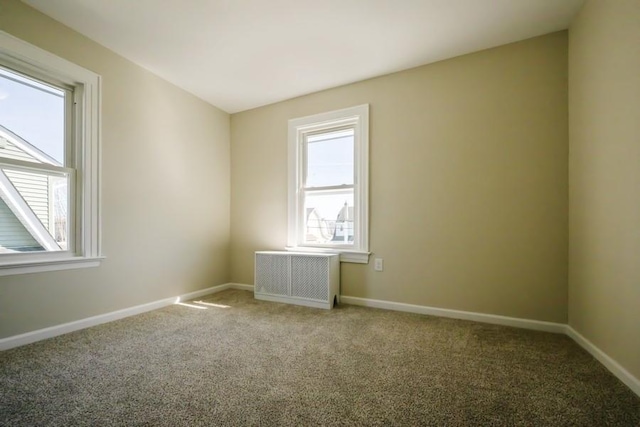 empty room with baseboards, carpet floors, and radiator