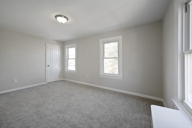 spare room featuring carpet and baseboards