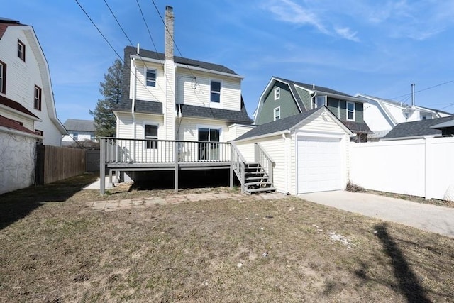 rear view of property with an outbuilding, driveway, roof with shingles, a wooden deck, and a fenced backyard