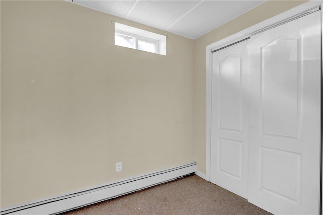 unfurnished bedroom with a closet, baseboard heating, and carpet flooring